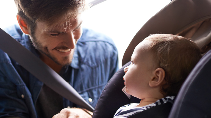 Man with small child in car